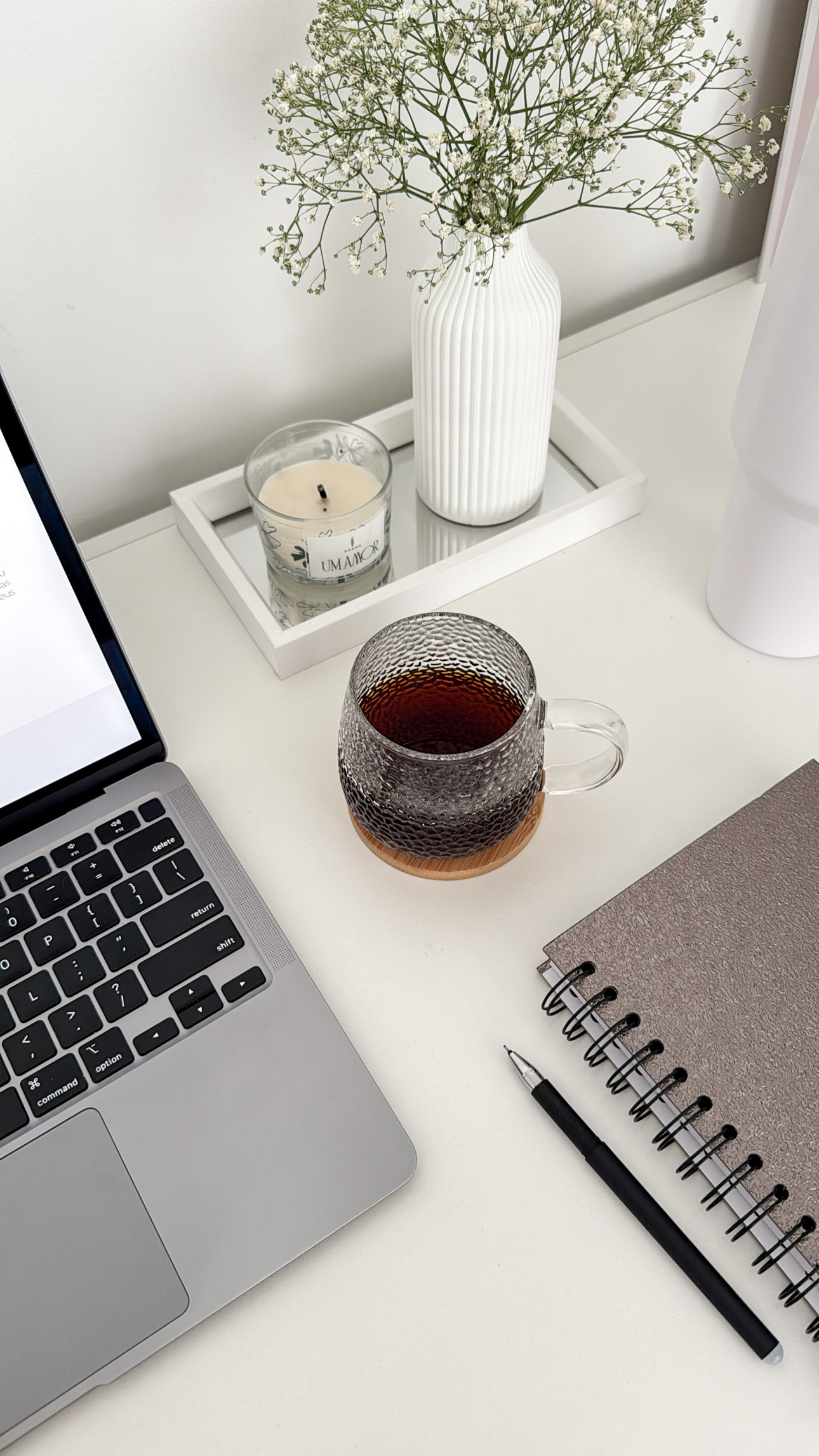 a computer and notebook on a desk with a cup of coffee